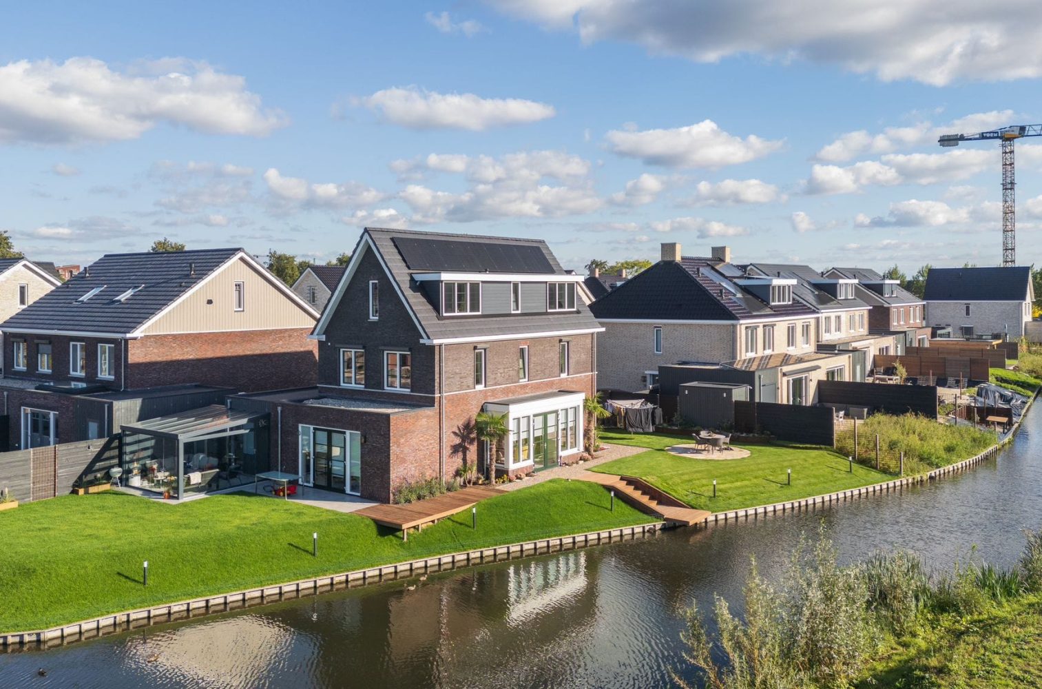 Moderne tuin aan het water in Pijnacker, ontworpen en aangelegd door Keko Hoveniers. De tuin heeft een strak gazon, houten vlonders bij het water en een sfeervol terras.